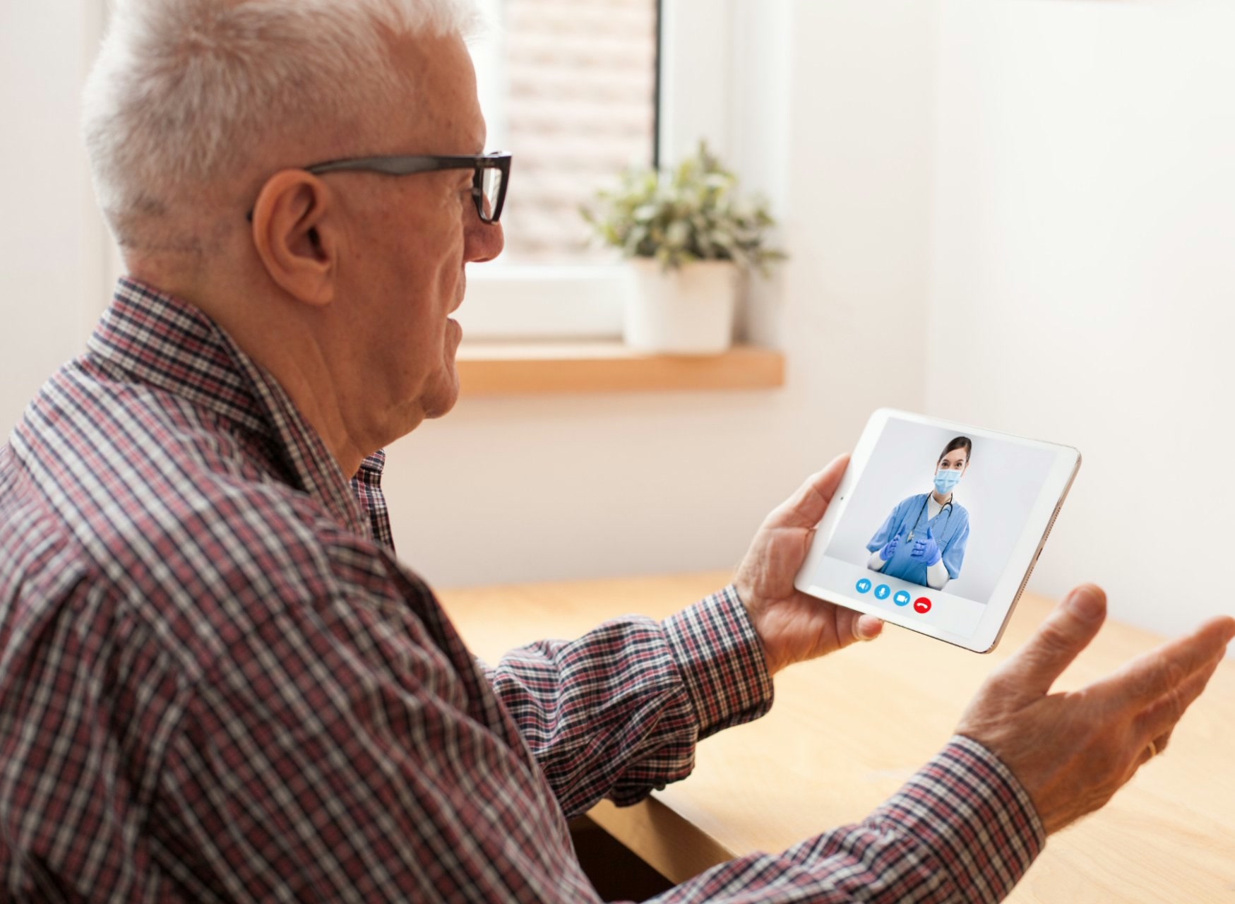 Older man using a tablet for a telehealth call